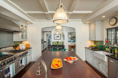 Example of a large transitional dark wood floor and brown floor kitchen design in Los Angeles with a farmhouse sink, shaker cabinets, gray cabinets, soapstone countertops, green backsplash, mosaic tile backsplash, stainless steel appliances, an island and black countertops