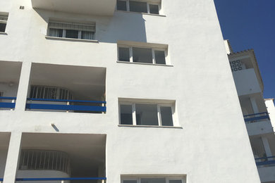 Modelo de fachada blanca marinera de tamaño medio de tres plantas con revestimientos combinados, tejado a dos aguas y tejado de teja de barro