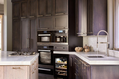 Eat-in kitchen - u-shaped light wood floor, brown floor and vaulted ceiling eat-in kitchen idea in Other with an undermount sink, recessed-panel cabinets, brown cabinets, granite countertops, white backsplash, ceramic backsplash, black appliances, an island and white countertops