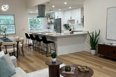 Example of a large trendy open concept vinyl floor and brown floor living room design in Tampa with white walls