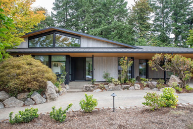 Inspiration for a mid-sized asian gray one-story wood house exterior remodel in Portland with a hip roof, a metal roof and a black roof