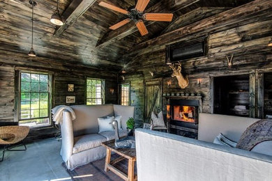 Inspiration for a mid-sized rustic formal and enclosed concrete floor and gray floor living room remodel in New York with brown walls, a standard fireplace, a metal fireplace and no tv