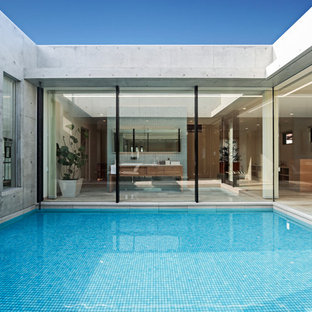 他の地域の大きいコンテンポラリースタイルのおしゃれな中庭プール (タイル敷き) の写真