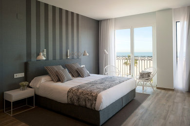 Diseño de dormitorio principal mediterráneo de tamaño medio con suelo de madera en tonos medios