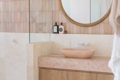 Example of a large minimalist pink tile single-sink bathroom design in Sunshine Coast with medium tone wood cabinets, marble countertops and pink countertops