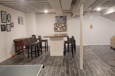 Example of a mid-sized classic underground porcelain tile, brown floor and exposed beam basement game room design in Chicago with white walls