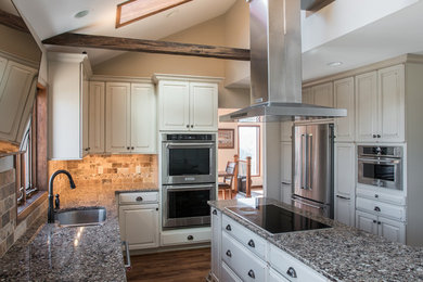 Inspiration for a mid-sized transitional l-shaped laminate floor eat-in kitchen remodel in Philadelphia with a double-bowl sink, raised-panel cabinets, distressed cabinets, quartzite countertops, beige backsplash, porcelain backsplash, stainless steel appliances and an island