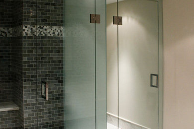 This is an example of a transitional bathroom in Toronto with a corner shower, a one-piece toilet, white walls, marble floors and an undermount sink.