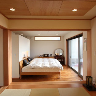 Ispirazione per una camera da letto etnica con pareti bianche, pavimento in legno massello medio e nessun camino