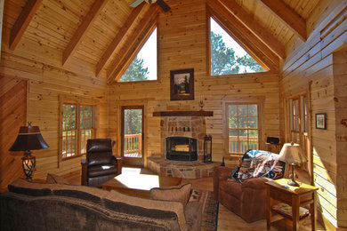 Example of a large mountain style formal and open concept medium tone wood floor and brown floor living room design in Denver with a standard fireplace and a stone fireplace