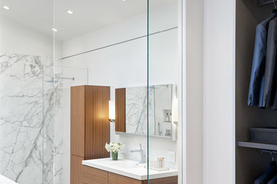 This is an example of a mid-sized modern master bathroom in San Francisco with flat-panel cabinets, dark wood cabinets, an open shower, a wall-mount toilet, white tile, ceramic tile, white walls, ceramic floors, an integrated sink, engineered quartz benchtops, white floor and white benchtops.