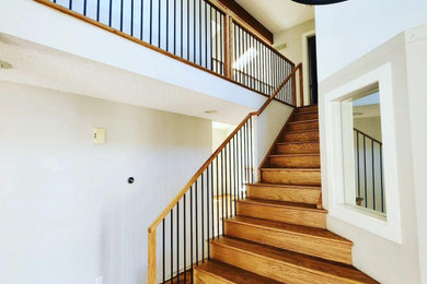 Photo of a large modern foyer in Denver with white walls, medium hardwood flooring and brown floors.