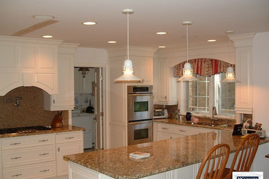 Large elegant u-shaped porcelain tile eat-in kitchen photo in Chicago with an undermount sink, granite countertops, gray backsplash, mosaic tile backsplash, stainless steel appliances and an island