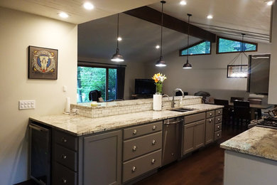 Mid-sized transitional galley dark wood floor eat-in kitchen photo in Other with recessed-panel cabinets, white backsplash, ceramic backsplash, stainless steel appliances, an island, an undermount sink and gray cabinets