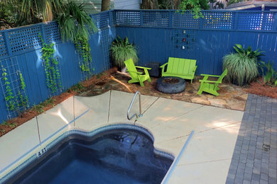 Design ideas for a coastal partial sun backyard concrete paver landscaping in Other with a fire pit.
