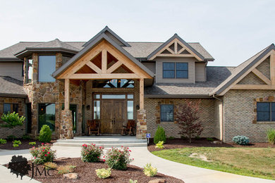 Example of a large mountain style brown three-story brick exterior home design in Other with a shingle roof