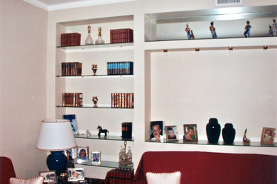 Diseño de biblioteca en casa minimalista grande con paredes beige y suelo de madera en tonos medios