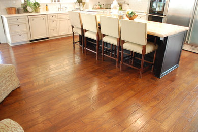 Inspiration for a mid-sized timeless l-shaped medium tone wood floor and brown floor open concept kitchen remodel in Seattle with an undermount sink, beaded inset cabinets, white cabinets, marble countertops, white backsplash, subway tile backsplash, stainless steel appliances and an island