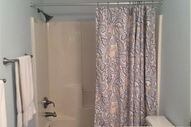 Example of a classic vinyl floor and gray floor bathroom design in Grand Rapids with raised-panel cabinets, beige cabinets, blue walls, an undermount sink and quartz countertops