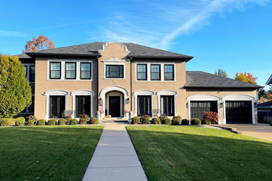 Large elegant beige two-story painted brick house exterior photo in St Louis with a hip roof, a shingle roof and a gray roof