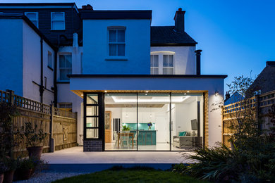 Contemporary stucco white duplex exterior in London with a flat roof.