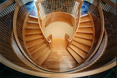 Inspiration for a huge wooden curved staircase remodel in Other with wooden risers