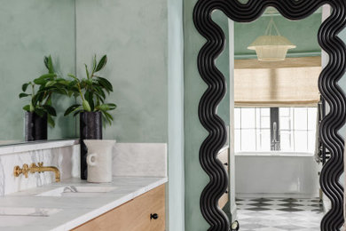 Example of an eclectic multicolored floor and double-sink bathroom design in Charlotte with flat-panel cabinets, medium tone wood cabinets, green walls, an undermount sink, white countertops and a floating vanity