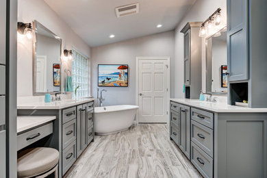 Bathroom - large transitional master gray tile and porcelain tile wood-look tile floor, gray floor, double-sink and vaulted ceiling bathroom idea in Oklahoma City with flat-panel cabinets, gray cabinets, a one-piece toilet, gray walls, an undermount sink, quartz countertops, white countertops, a niche and a built-in vanity