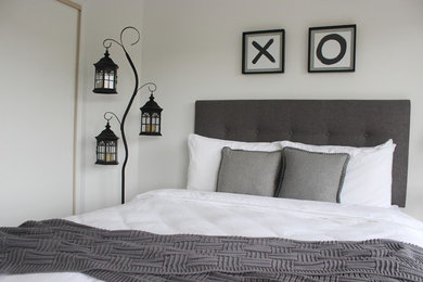 Photo of a mid-sized modern guest bedroom in Gold Coast - Tweed with white walls, carpet, no fireplace and grey floor.