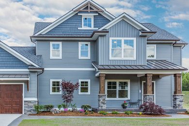 Mid-sized arts and crafts blue two-story vinyl exterior home photo in Grand Rapids with a mixed material roof