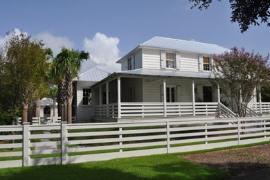 Beach style white two-story wood exterior home photo in Charleston with a hip roof