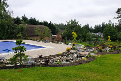 Foto de jardín tradicional grande en patio trasero con estanque y adoquines de hormigón