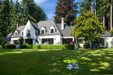 Large traditional white two-story stucco exterior home idea in Seattle with a shingle roof
