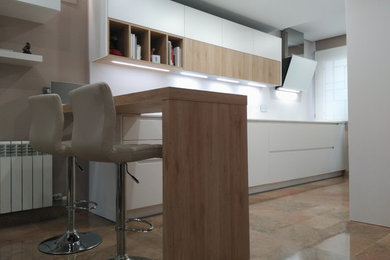 Mid-sized modern single-wall eat-in kitchen in Other with an integrated sink, flat-panel cabinets, white cabinets and a peninsula.