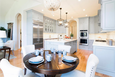 Open concept kitchen - large transitional u-shaped light wood floor open concept kitchen idea in San Francisco with an undermount sink, beaded inset cabinets, gray cabinets, quartz countertops, beige backsplash, ceramic backsplash, stainless steel appliances and an island