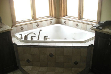 Example of a mid-sized classic master beige tile and ceramic tile ceramic tile and beige floor corner bathtub design in Salt Lake City with raised-panel cabinets, dark wood cabinets, beige walls, an undermount sink and granite countertops
