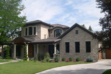 Large traditional beige two-story stone exterior home idea in Denver