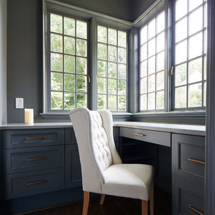 Design ideas for a small modern craft room in Charlotte with blue walls, dark hardwood flooring, no fireplace and a built-in desk.