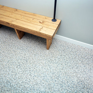 This is an example of a medium sized modern fully buried basement in Calgary with grey walls, porcelain flooring and no fireplace.