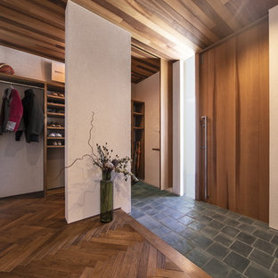 На фото: большие узкие прихожие в стиле ретро с белыми стенами, одностворчатой входной дверью, входной дверью из дерева среднего тона и черным полом