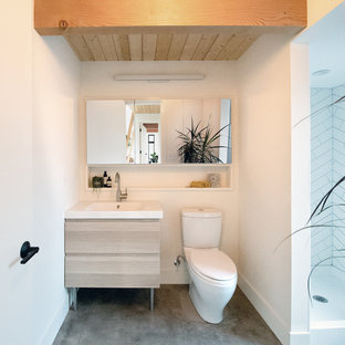 Immagine di una stanza da bagno minimalista con ante lisce, ante in legno chiaro, doccia alcova, WC a due pezzi, piastrelle bianche, piastrelle in ceramica, pareti bianche, pavimento in cemento, lavabo integrato, pavimento grigio, doccia con tenda e top giallo