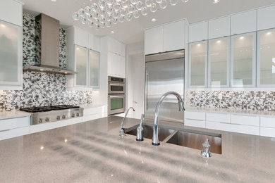 Example of a large trendy porcelain tile kitchen design in Edmonton with an undermount sink, flat-panel cabinets, white cabinets, quartzite countertops, glass tile backsplash, stainless steel appliances and an island