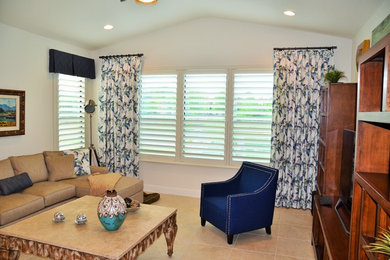 Example of a mid-sized trendy enclosed ceramic tile and beige floor family room design in Orlando with white walls, a tv stand and no fireplace