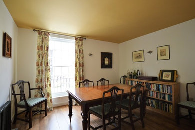 Inspiration for a medium sized classic dining room in London with white walls and medium hardwood flooring.