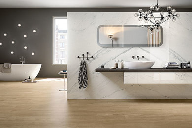 Freestanding bathtub - large modern master porcelain tile freestanding bathtub idea in Nashville with flat-panel cabinets, white cabinets, a vessel sink and quartz countertops
