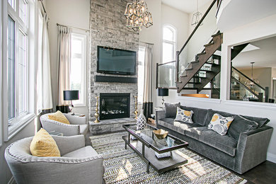 Example of a trendy open concept medium tone wood floor and brown floor family room design in Toronto with white walls, a standard fireplace, a stone fireplace and a wall-mounted tv