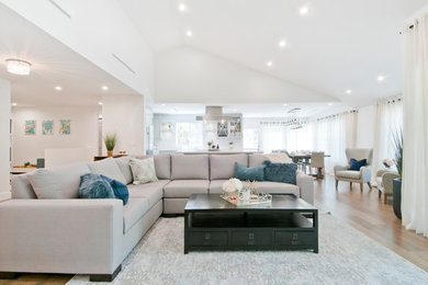 Large transitional open concept laminate floor living room photo in Los Angeles with gray walls, no fireplace and a media wall