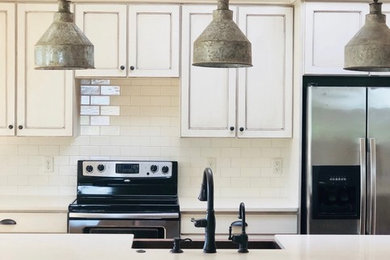 Inspiration for a cottage medium tone wood floor kitchen remodel in Other with raised-panel cabinets, distressed cabinets, quartz countertops and beige countertops