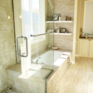 Ispirazione per una stanza da bagno padronale tradizionale con ante con bugna sagomata, ante beige, vasca sottopiano, doccia ad angolo e pareti beige
