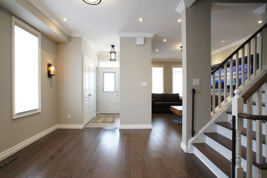 Large transitional medium tone wood floor hallway photo in Toronto with gray walls